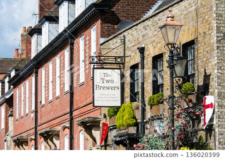 A historic brick building decorated with a pub sign and plants in bright sunlight in Windsor, a suburb of London A historic brick building decorated with a pub sign and plants in bright sunlight in Windsor, a suburb of London 136020399