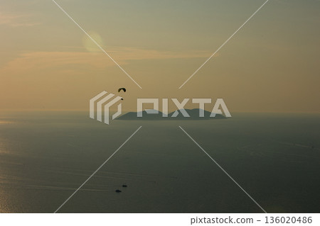 Mountain range rising above a calm blue sea under a clear sky, forming a minimalistic coastal landscape. Serene natural scenery captured on August 2025. Mountain range rising above a calm blue sea under a clear sky, forming a minimalistic coastal landscape. Serene natural scenery captured on August 2025. 136020486