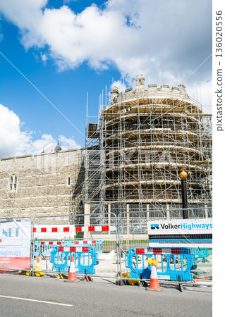 歷史悠久的溫莎城堡，石砌結構，鷹架正在搭建，天空湛藍，白雲飄浮。這是倫敦郊區的一條街景。 136020556