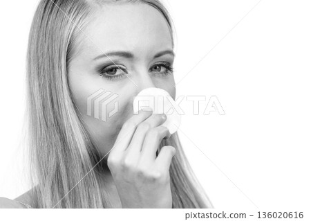Woman cleaning her face skin with cotton pad 136020616