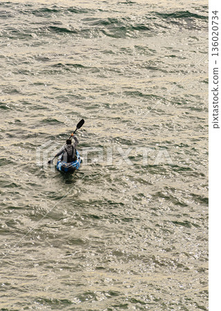 Person kayaking on sea. 136020734