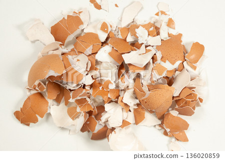 Pile of broken brown eggshell isolated on white background. Pile of broken brown eggshell isolated on white background. 136020859