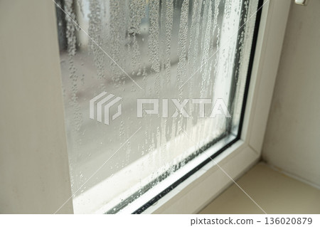 Close up of misted window glass with water streaks and droplets Close up of misted window glass with water streaks and droplets 136020879
