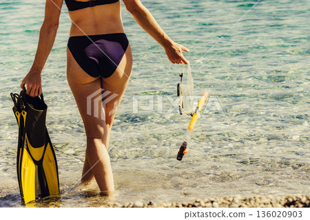Woman with flippers snorkeling tube on beach Woman with flippers snorkeling tube on beach 136020903