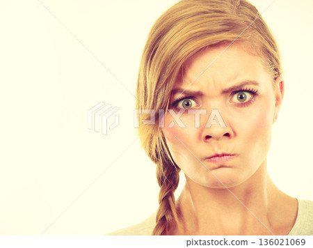 Teenage girl in braid hair making angry face Teenage girl in braid hair making angry face 136021069