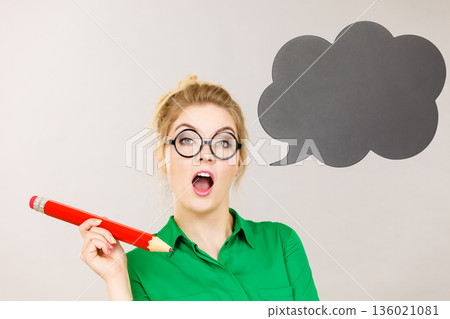 Woman holding big oversized pencil thinking 136021081