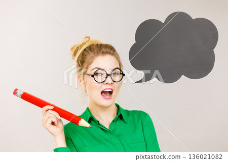 Woman holding big oversized pencil thinking 136021082
