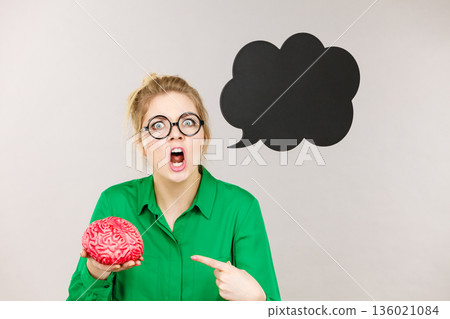 Business woman intensive thinking holding brain Business woman intensive thinking holding brain 136021084