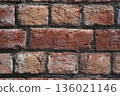 Brick wall. Close-up of a fresh brickwork. The red, hand-made uneven bricks, with visible clay layers and a rough texture, were neatly laid in cement mortar in South Asia. 136021146