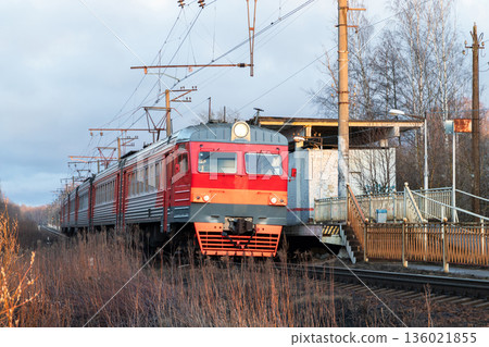 A bright red electric passenger train on a sunny day A bright red electric passenger train on a sunny day 136021855