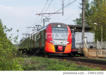 A bright red orange modern passenger train A bright red orange modern passenger train 136021856