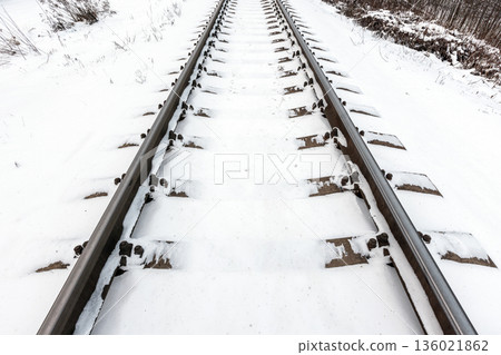 Perspective view of a snow covered railroad tracks in winter 136021862