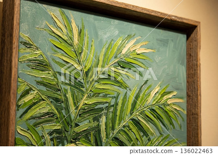 Textured oil paint on canvas showing green palm leaves in rustic wooden frame close up detail 136022463