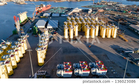 Offshore wind turbine foundations storage at port logistics terminal aerial view 136023086