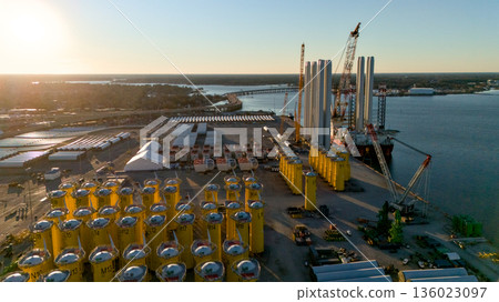 Aerial view of wind turbine tower sections at port logistics hub Aerial view of wind turbine tower sections at port logistics hub 136023097