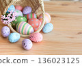 Basket with Easter colorful eggs on wooden table 136023125