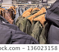 Exploring a vibrant clothing store with stylish jackets on display 136023158