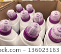 Containers of liquid detergent arranged neatly in a cardboard box indoors 136023163