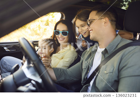 Smiling family driving car on road trip, happy parents with children enjoying ride 136023231