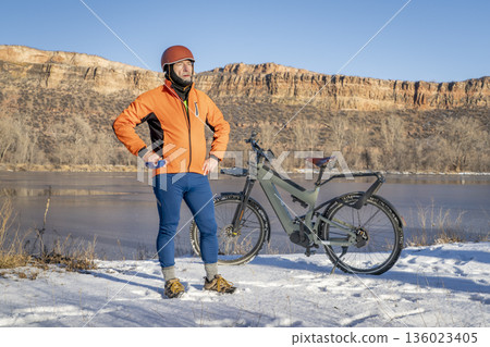 senior male cyclist with a touring electric bike in Colorado foothills in winter scenery senior male cyclist with a touring electric bike in Colorado foothills in winter scenery 136023405