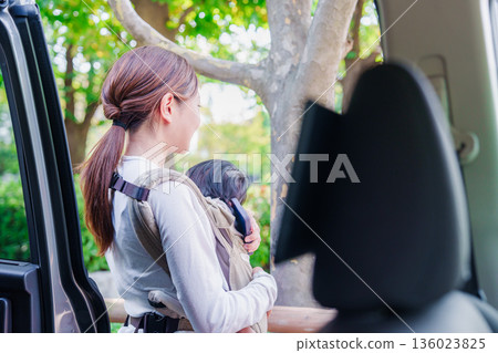 A woman riding in a taxi with her child in a baby carrier A woman riding in a taxi with her child in a baby carrier 136023825