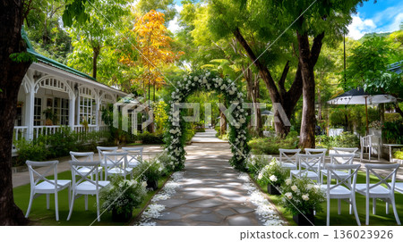 Enchanting Outdoor Wedding Ceremony Venue with Arch and Seating Surrounded by Lush Greenery and Sunlight 136023926