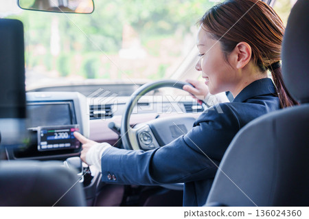 A smiling female taxi driver giving fare information 136024360