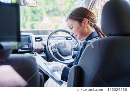Smiling taxi driver woman Smiling taxi driver woman 136024386