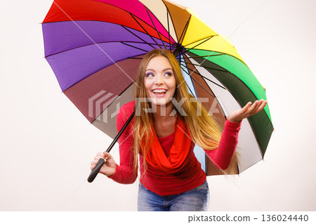 Woman standing under multicolored umbrella 136024440