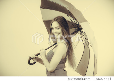 Woman in summer dress holds umbrella 136024441