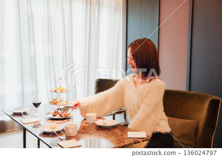 A female staff member recommending wine to a customer A female staff member recommending wine to a customer 136024797