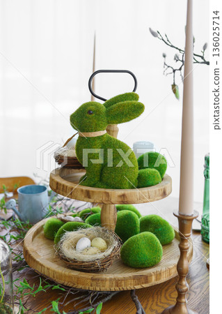 Green moss Easter Bunny and decorative Easter eggs in nest on on two tiered wooden plate Green moss Easter Bunny and decorative Easter eggs in nest on on two tiered wooden plate 136025714