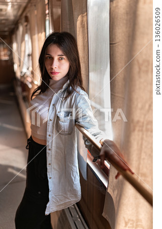 Young Woman Standing in a Train Car with Sunlight Young Woman Standing in a Train Car with Sunlight 136026509