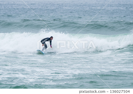 Surfer girl riding a wave Surfer girl riding a wave 136027504