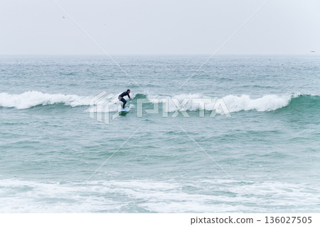 Surfer girl riding a wave Surfer girl riding a wave 136027505