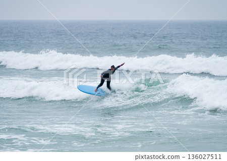 Surfer girl riding a wave Surfer girl riding a wave 136027511