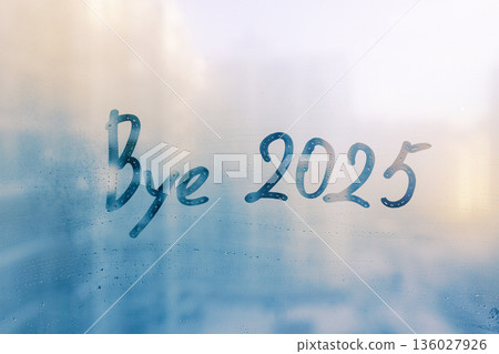 Lettering bye and numbers 2025 paint with finger with streaks of water on splashed by rain foggy glass on blue window Lettering bye and numbers 2025 paint with finger with streaks of water on splashed by rain foggy glass on blue window 136027926