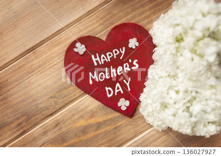 Red heart with white inscription happy Mother's day on brown old wooden background with white hydrangea flowers Red heart with white inscription happy Mother's day on brown old wooden background with white hydrangea flowers 136027927