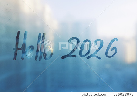 Handwritten lettering Hello and arabic numerals 2026 on misted glass on blue sunset window 136028073