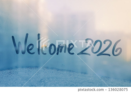 lettering Welcome and numbers 2026 of new year paint with finger on splashed by rain foggy glass on blue sunset window lettering Welcome and numbers 2026 of new year paint with finger on splashed by rain foggy glass on blue sunset window 136028075