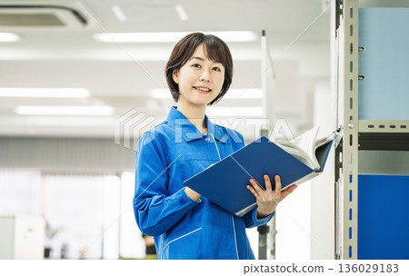 Portrait of a young woman in work clothes 136029183