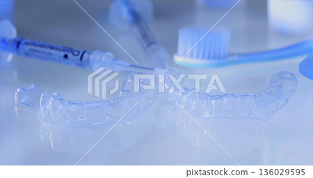Dental tools and aligners are placed on a table with dental care products during an orthodontic session in a clinic 136029595