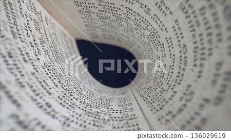 Looking through a rolled newspaper with clear text and dark background in a simple indoor setting Looking through a rolled newspaper with clear text and dark background in a simple indoor setting 136029619