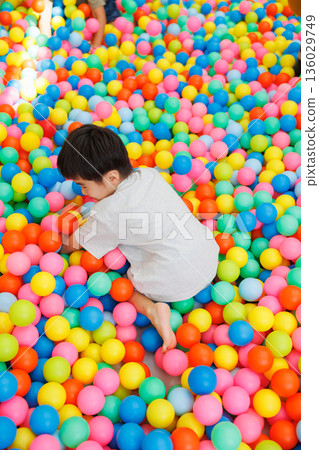 Boy playing in the ball pool Boy playing in the ball pool 136029749