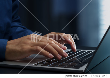 Business person using laptop at office desk. Close up of hands and keyboard. 136031048