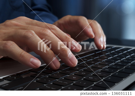 Business person using laptop at office desk. Close up of hands and keyboard. Business person using laptop at office desk. Close up of hands and keyboard. 136031111