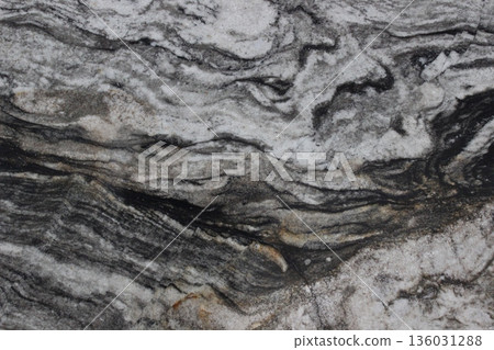 Close up of Copacabana marble showing white crystal fibers on a black base forming a natural water flow pattern. Close up of Copacabana marble showing white crystal fibers on a black base forming a natural water flow pattern. 136031288