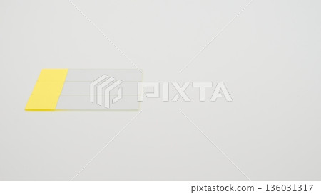 A low-angle photo of a glass slide placed in the middle left of a white background 136031317