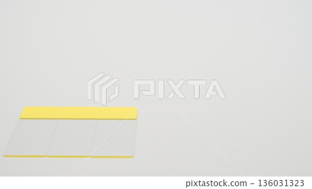 A low-angle photo of a glass slide placed vertically on the bottom left of a white background A low-angle photo of a glass slide placed vertically on the bottom left of a white background 136031323