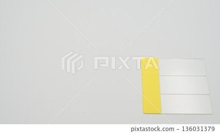 A standard-angle photograph of a glass slide placed vertically on the bottom right of a white background 136031379